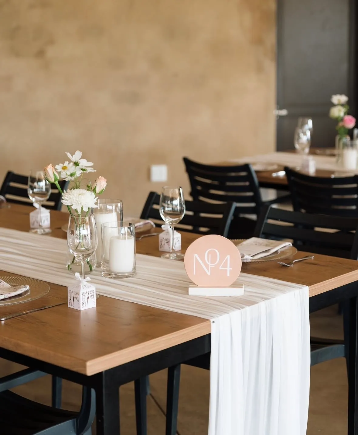 A reception hall styled with hanging bulb lights and a statement chandelier frame.