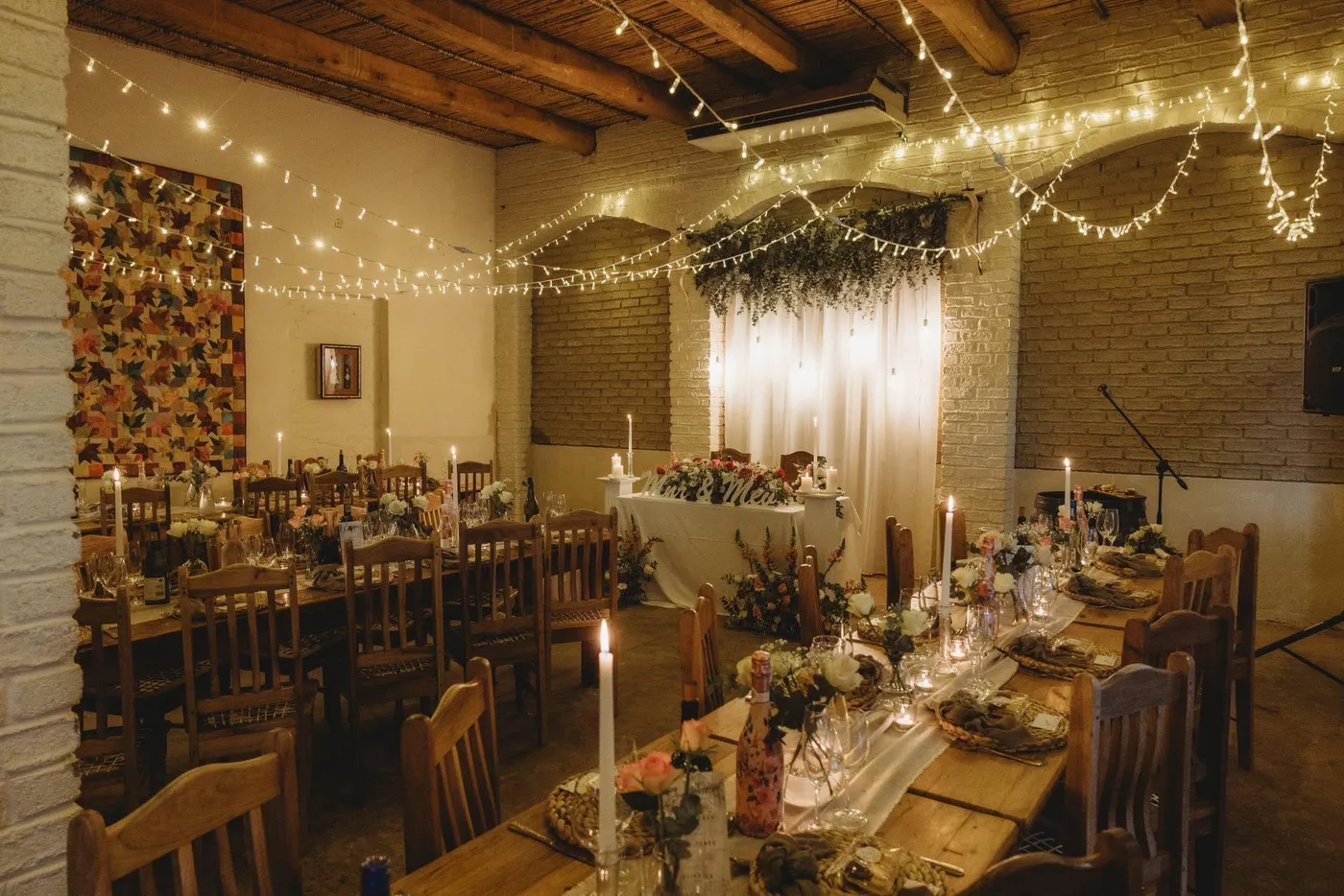 A rustic reception hall strung with fairy lights.