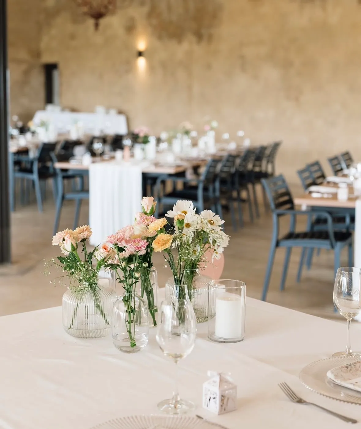 A bud vase centerpiece styled on a rustic reception table.